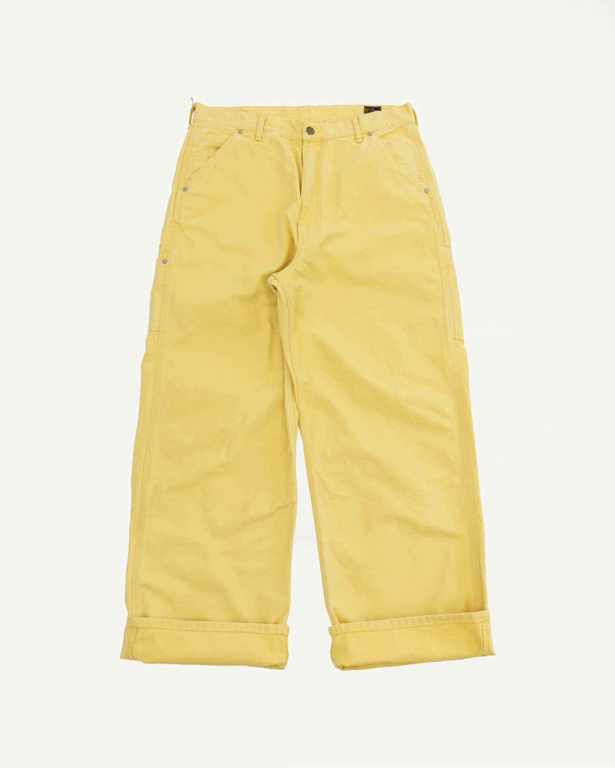 Front view of yellow wide-leg pants with cuffed hems and button details