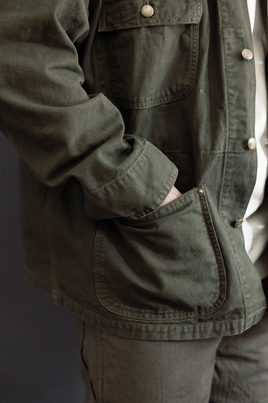 Medium shot, side view of an olive green canvas jacket on a 5'9