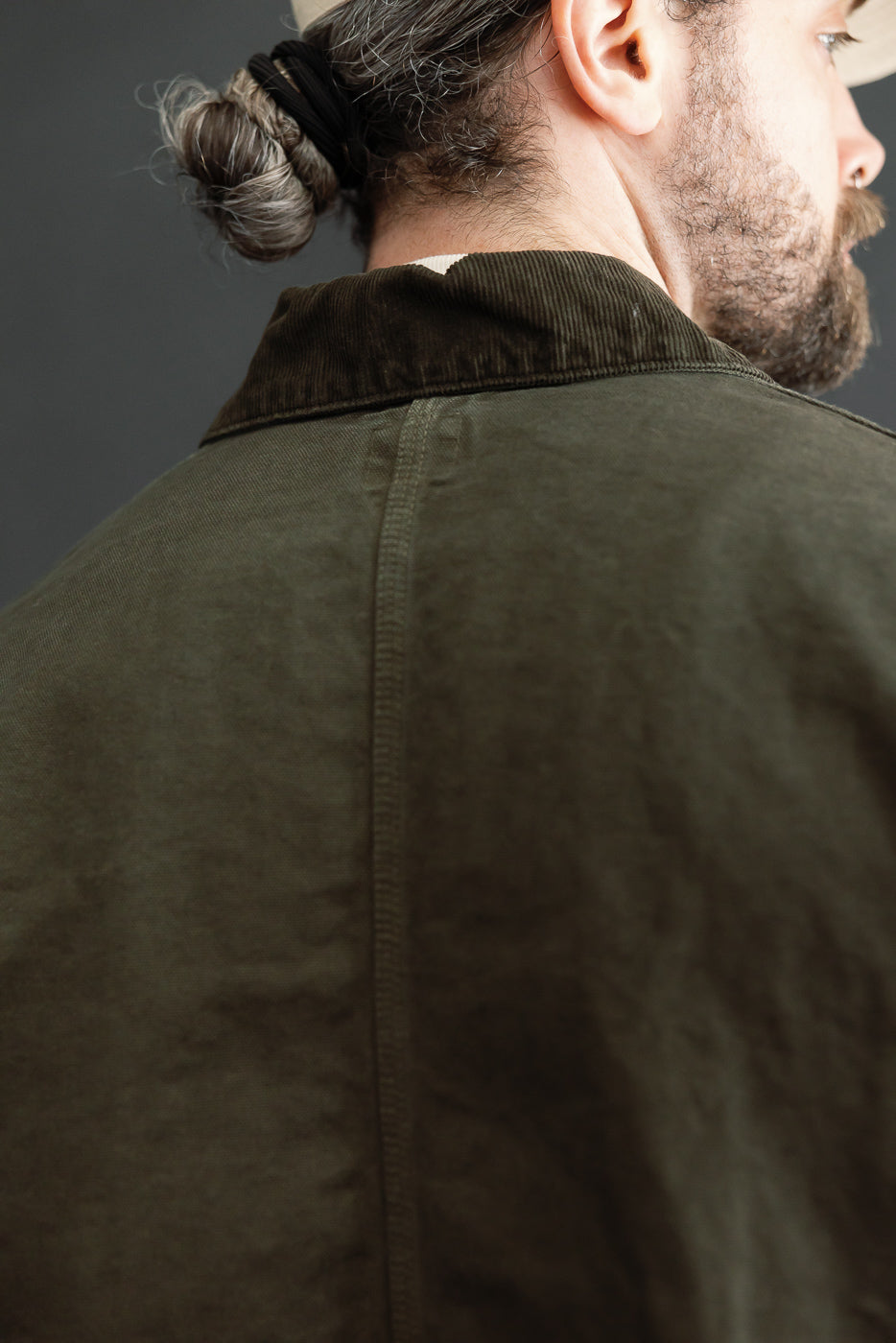 Close-up back view of olive green jacket on male model, 5'9