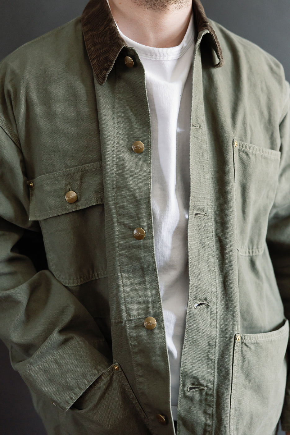 Close-up front of army green relaxed fit coverall jacket on 5'9