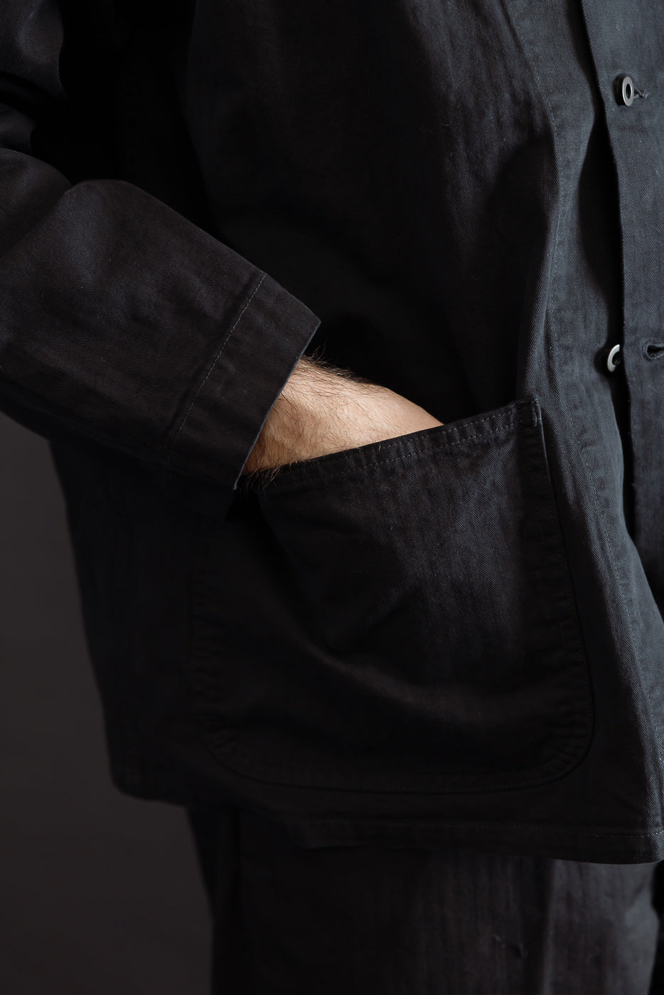 Close-up side view of a black casual shirt pocket on a male model, 5'9