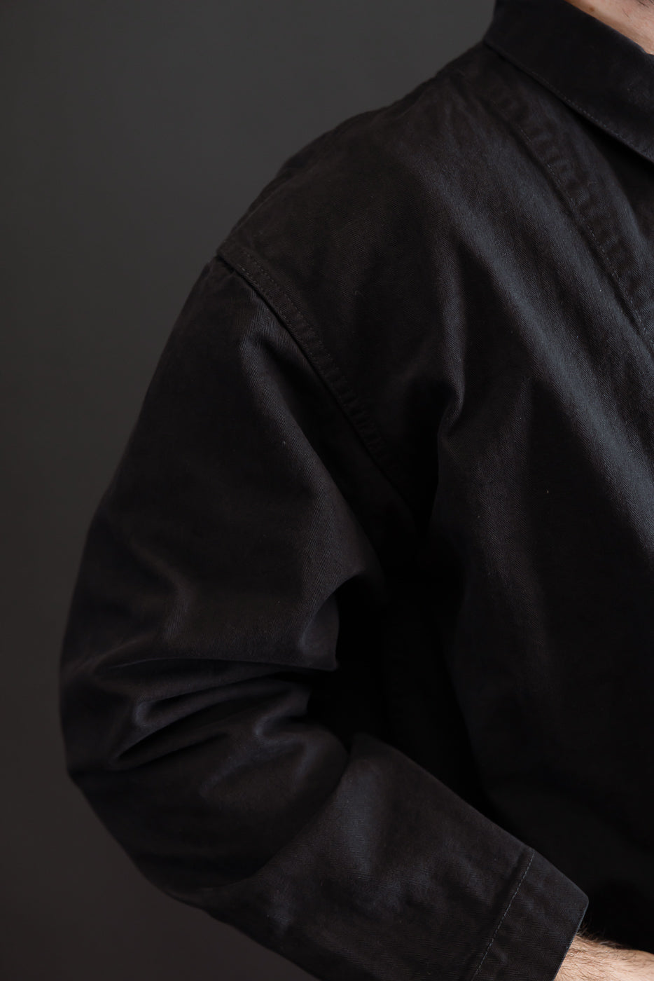 Close-up of the side and shoulder of a black cotton shirt on a 5'9