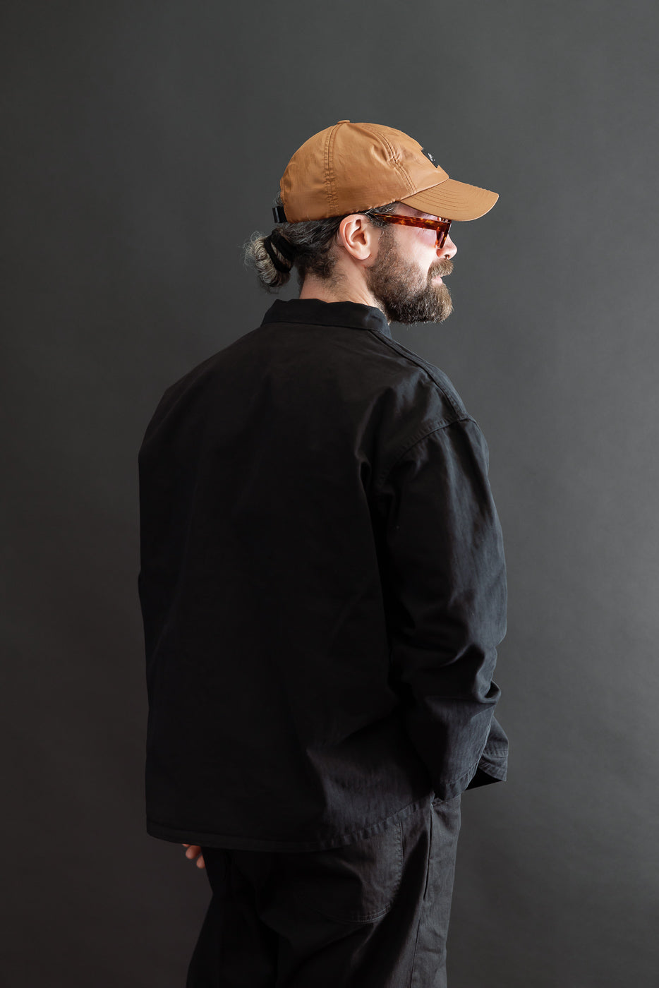 Back view of a black work jacket on a 5'9