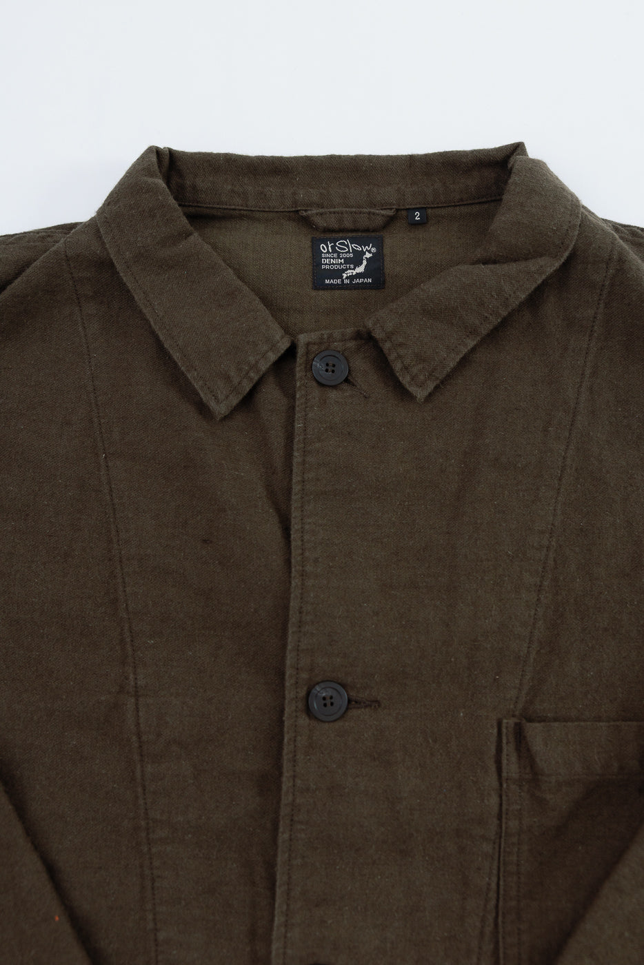 Close-up front view of Orslow moleskin work jacket in coffee brown showing collar, buttons, and chest pocket details for Dant contemporary casual apparel.