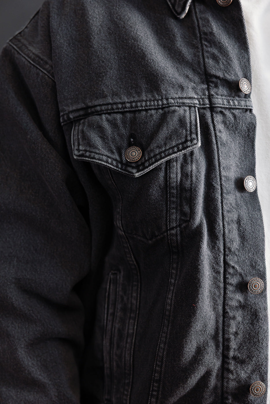 Close-up front view of orSlow black denim jacket chest pocket, snap buttons, and collar detail.