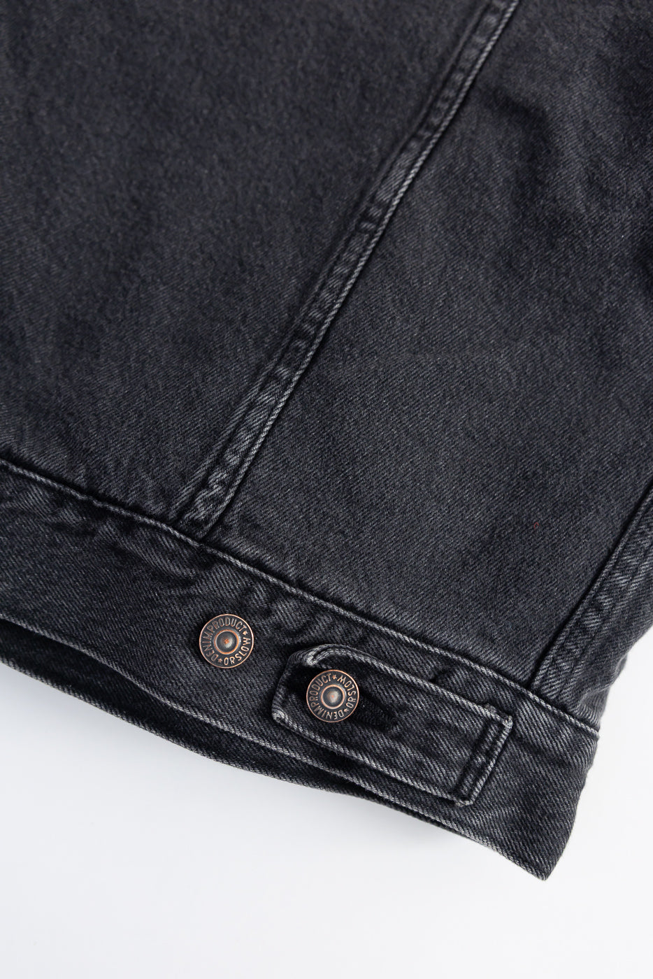Close-up of orSlow black denim jacket back hem with metal buttons, texture detail, Dant