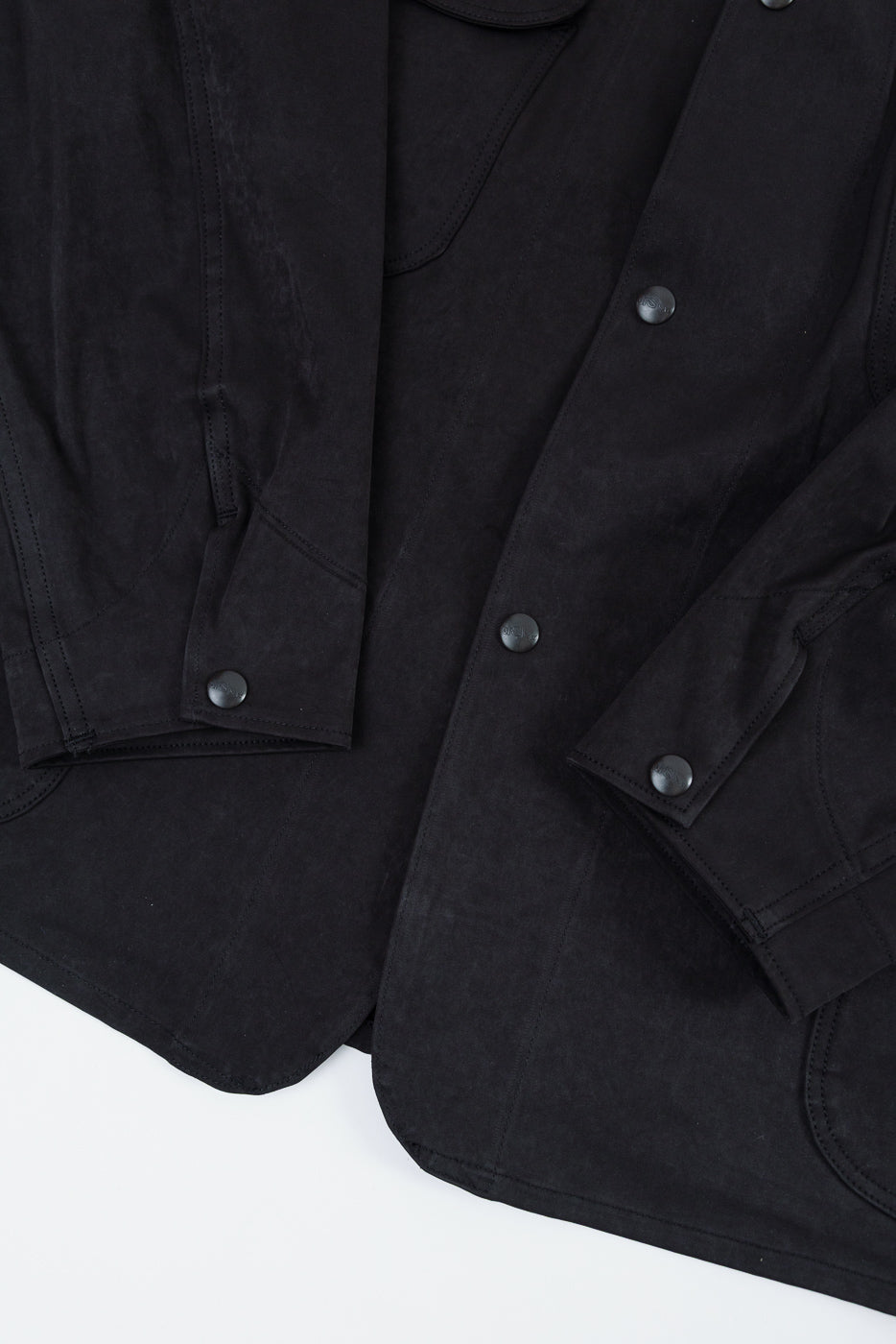 Close-up of the front of a black jacket showing buttons and fabric texture.