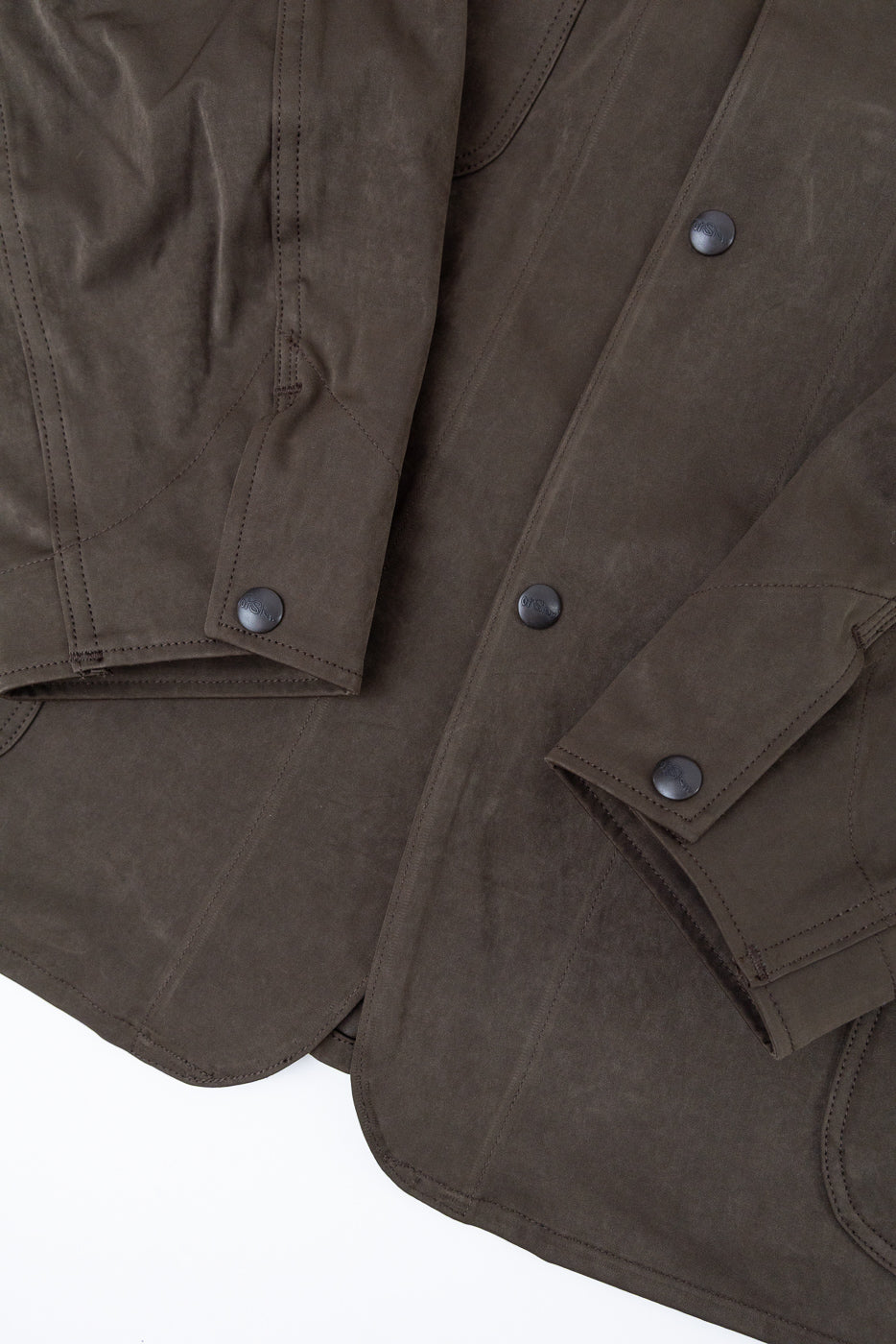 Close-up of the front right sleeve and bodice of a brown jacket showing buttons and fabric texture.