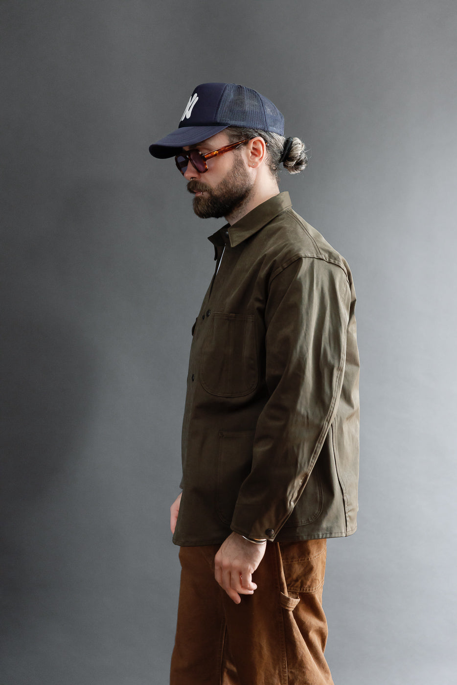 Side view of an olive green button-up shirt on a 5'9