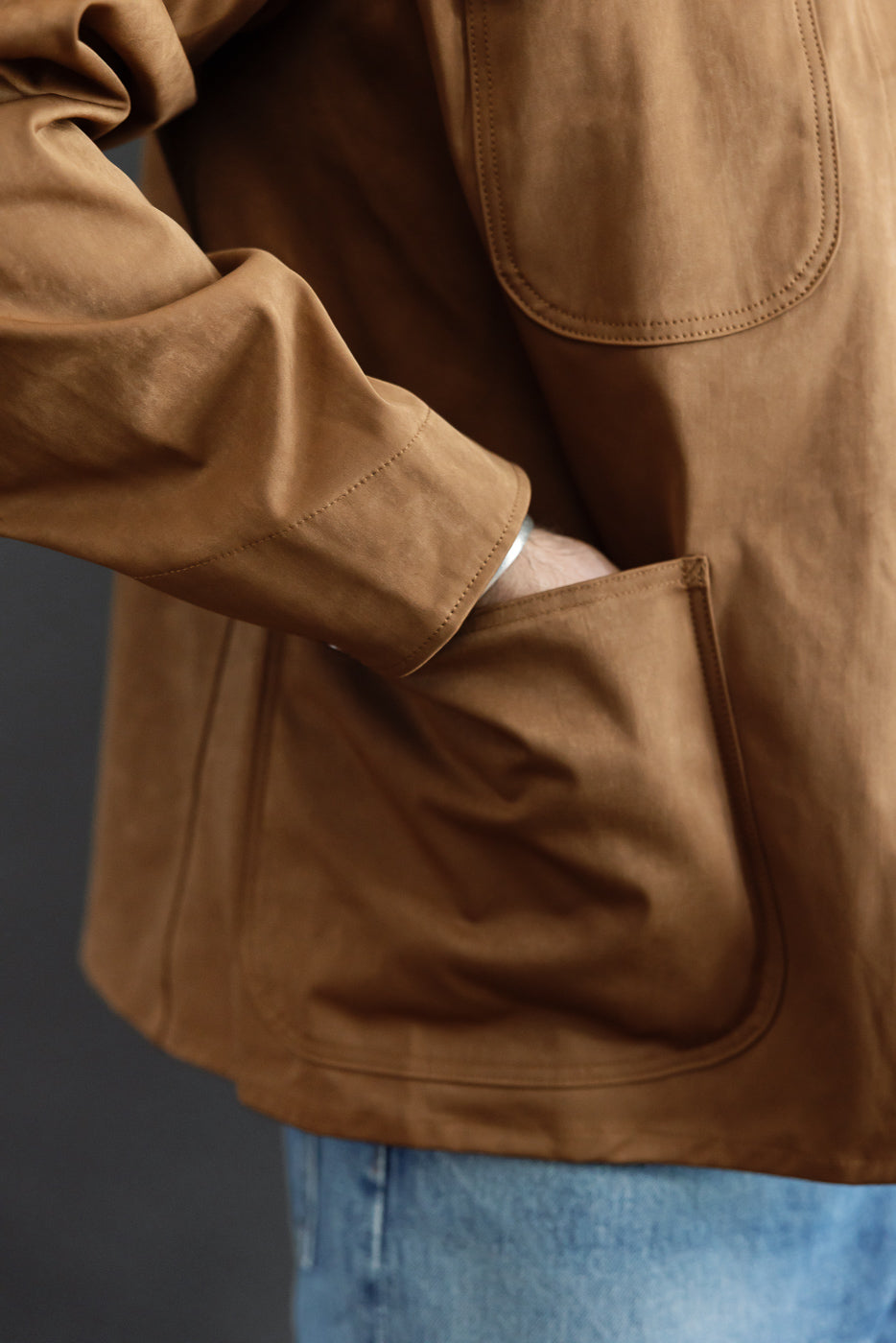 Close-up of the left side and pocket of a brown jacket on a male model, 5'9