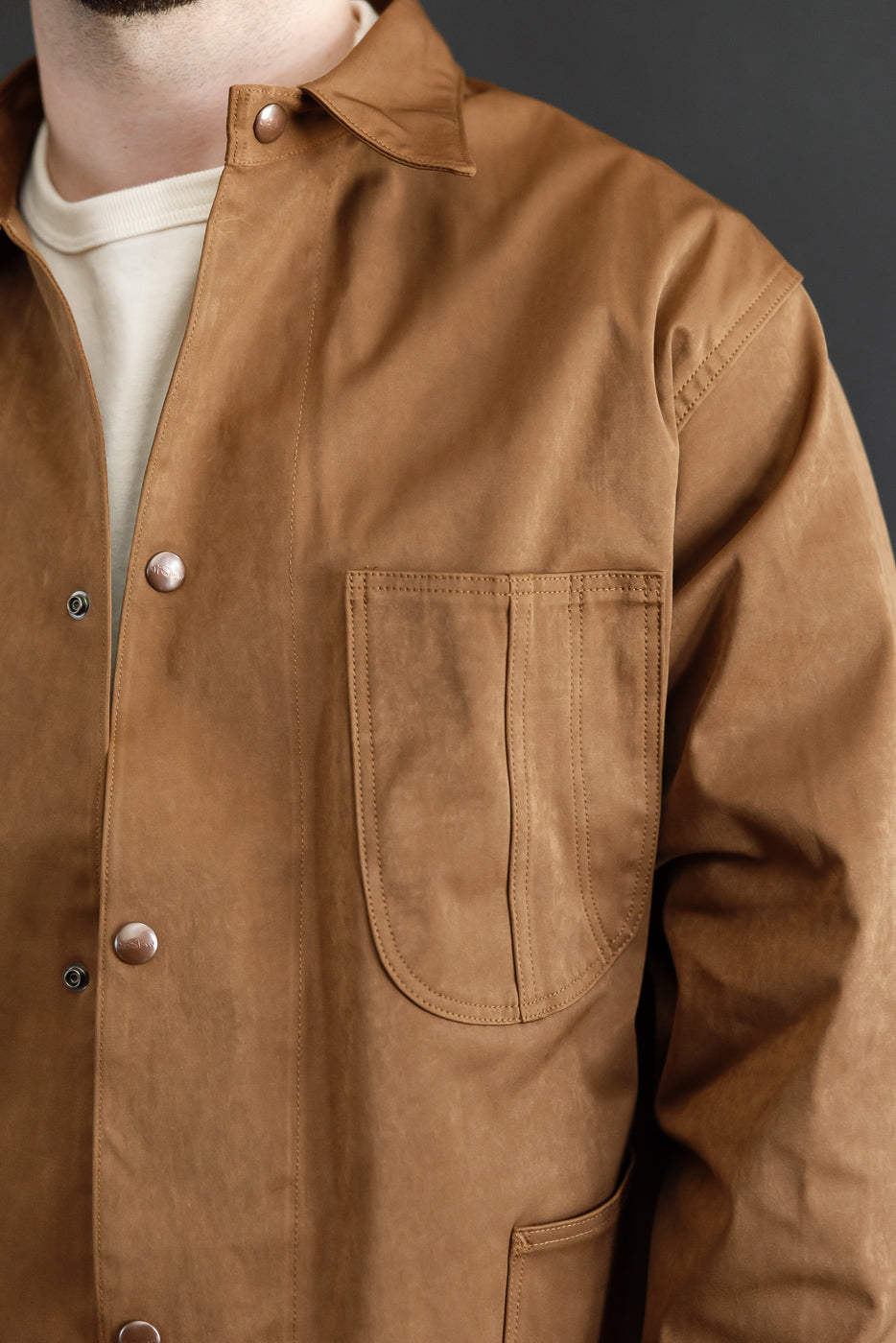 Close-up front view of a brown jacket on a male model (5'9