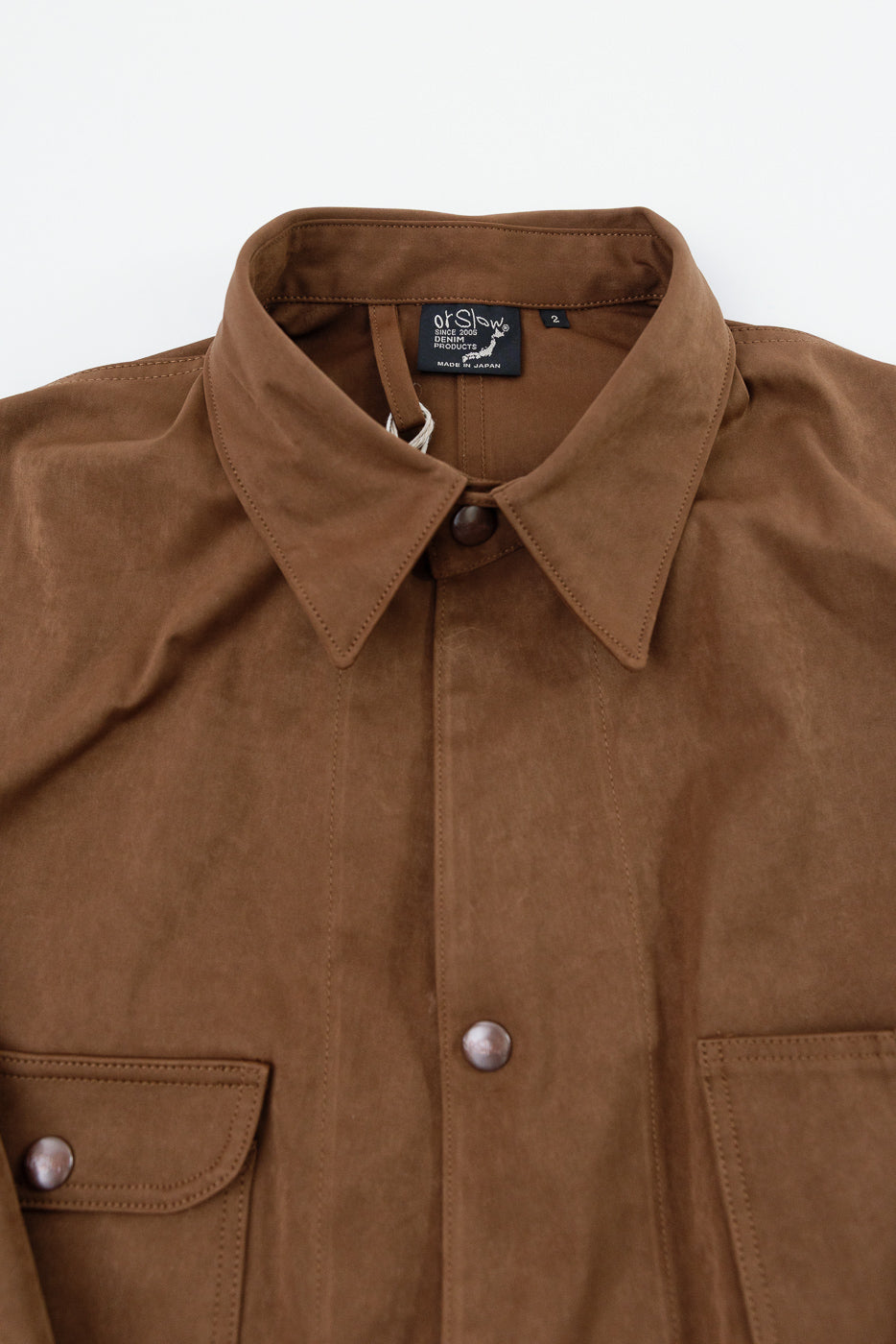 Close-up front view of a brown button-down shirt showing the pointed collar and button placket.