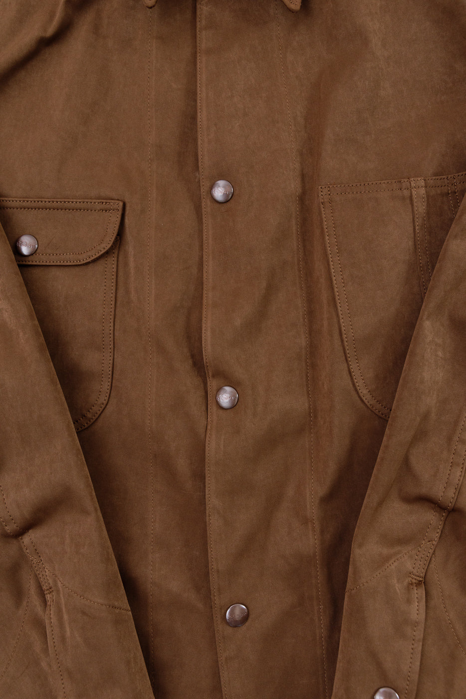 Close-up of the front of a brown suede jacket showing buttons and chest pockets.