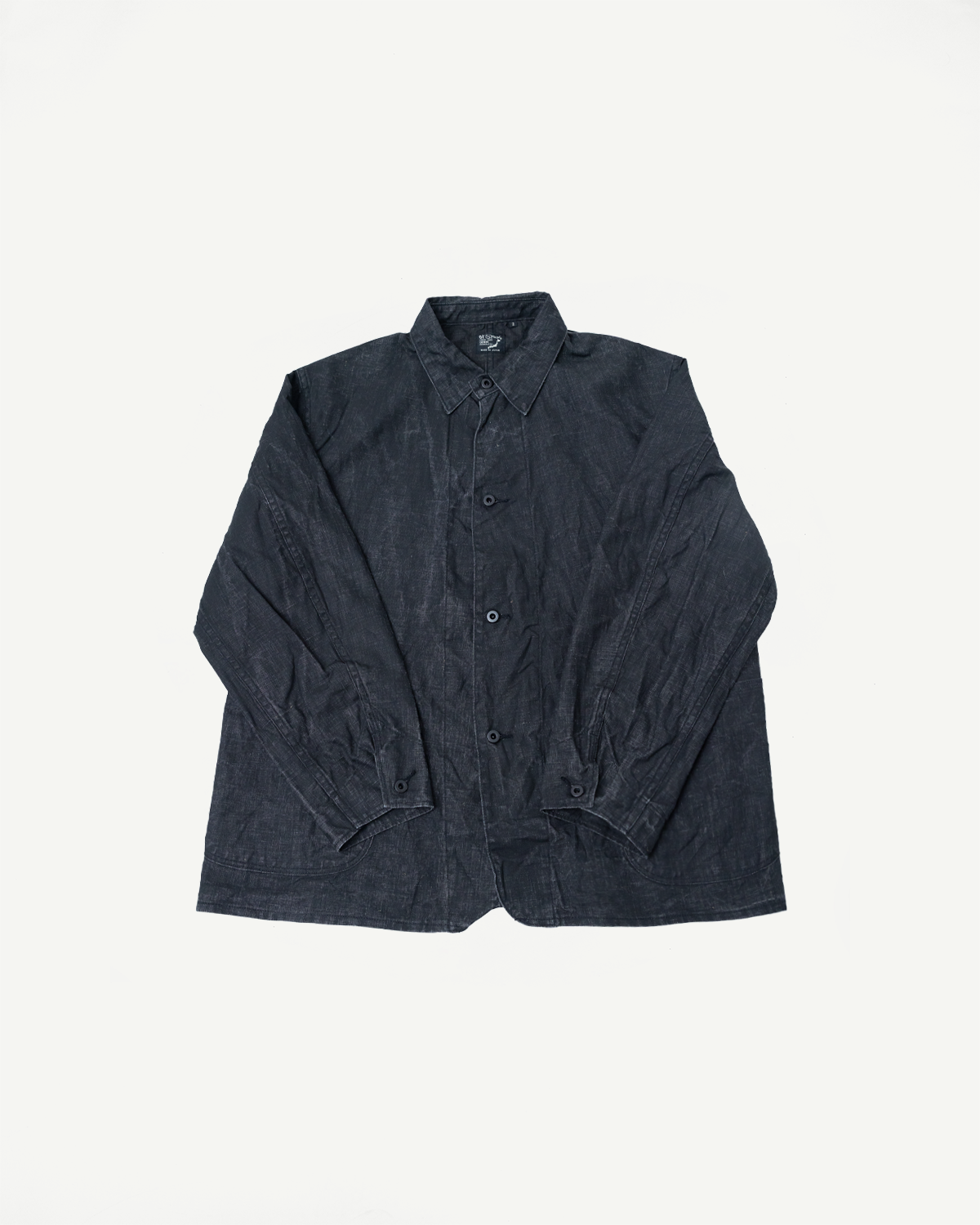 Flat lay front view of black linen coverall, showing collar, buttons, and textured fabric.
