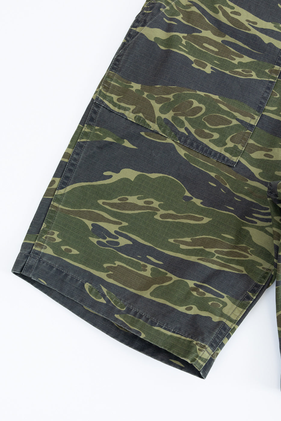 Close-up of the orSlow 01-7002-TGC Fatigue Shorts in tiger camo, featuring a relaxed straight fit with side-tab waist adjustments and period-correct buttons, highlighting the detailed craftsmanship.