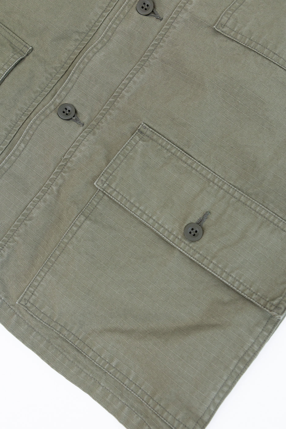 Close-up of the orSlow 01-8046-76k Utility Short Sleeve Work Shirt Jacket in Army Green, showcasing its durable ripstop cotton, relaxed shirt-jacket silhouette, and functional flap pockets with four-hole buttons.