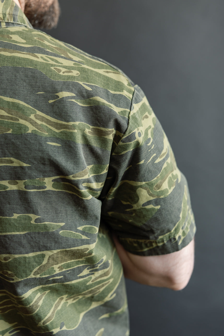 Close-up of the 01-8046 -TGC - Utility Short Sleeve Work Shirt Jacket - Tiger Camo, highlighting the green tiger-stripe camouflage pattern and relaxed fit on the upper back and shoulder.