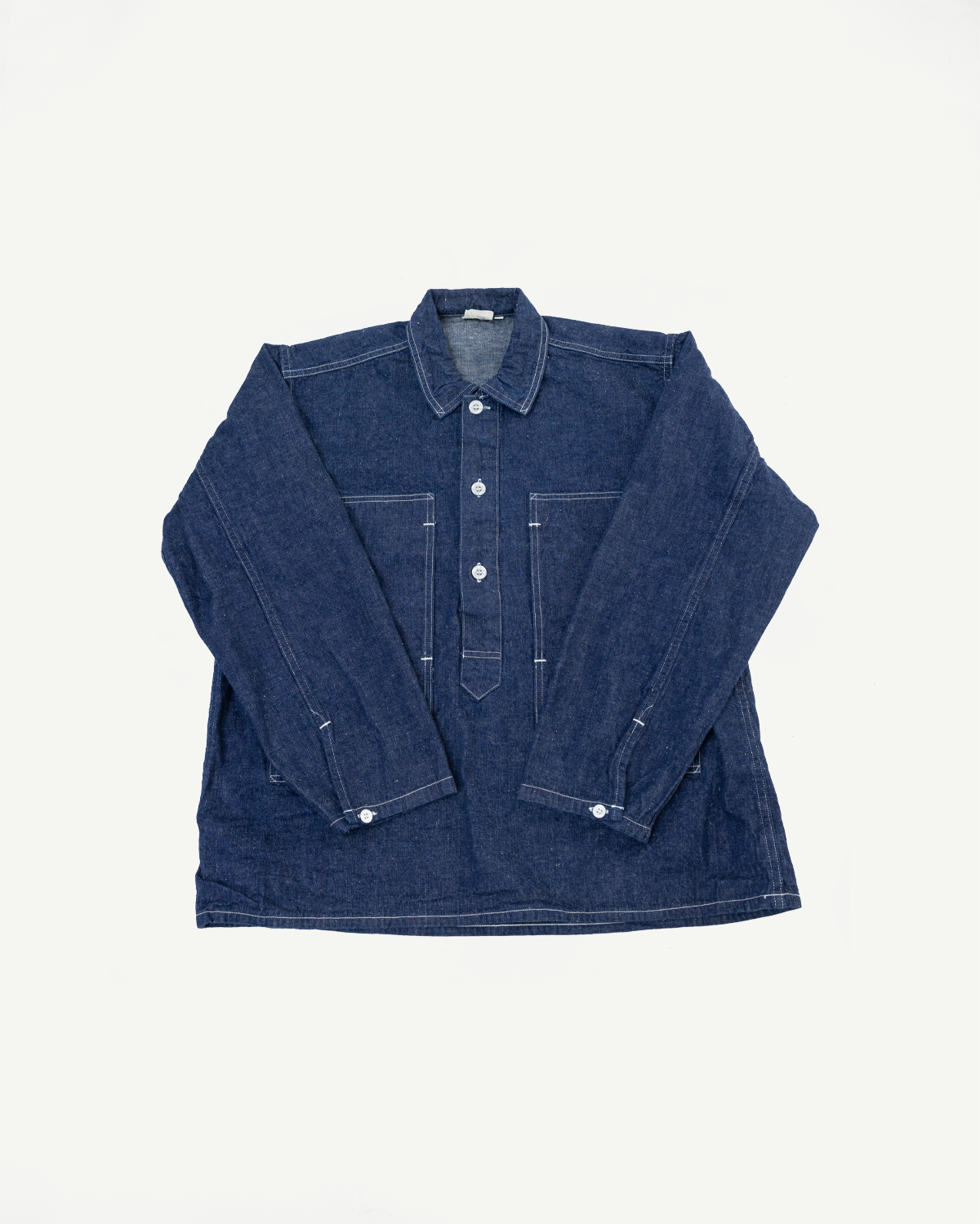 Front view flat lay of a dark indigo denim long sleeve shirt with white contrast stitching.