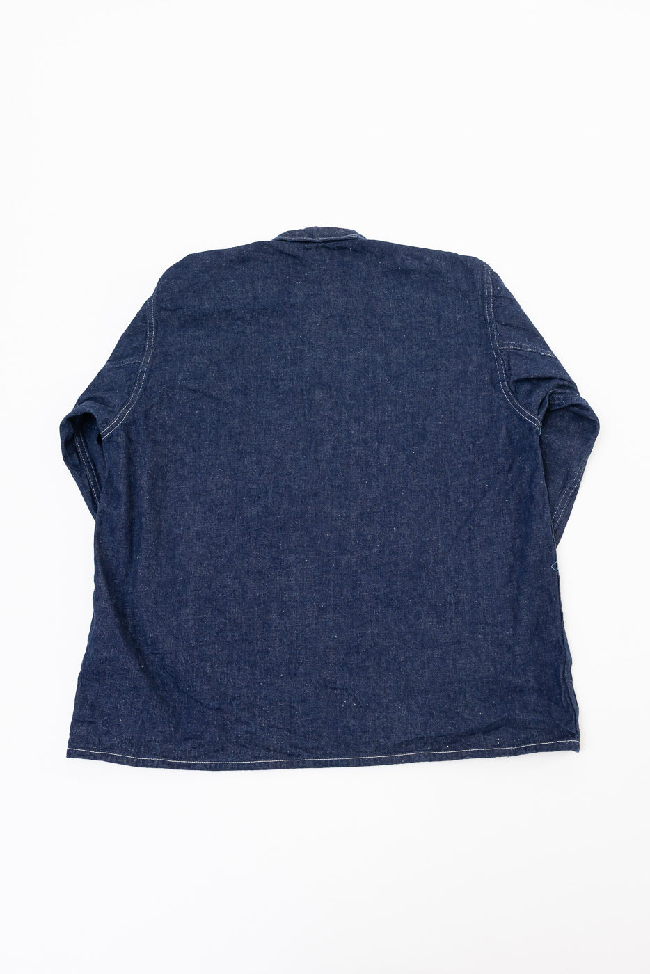 Flat lay, back view of a dark indigo denim long sleeve shirt showing the rear panel and hem.