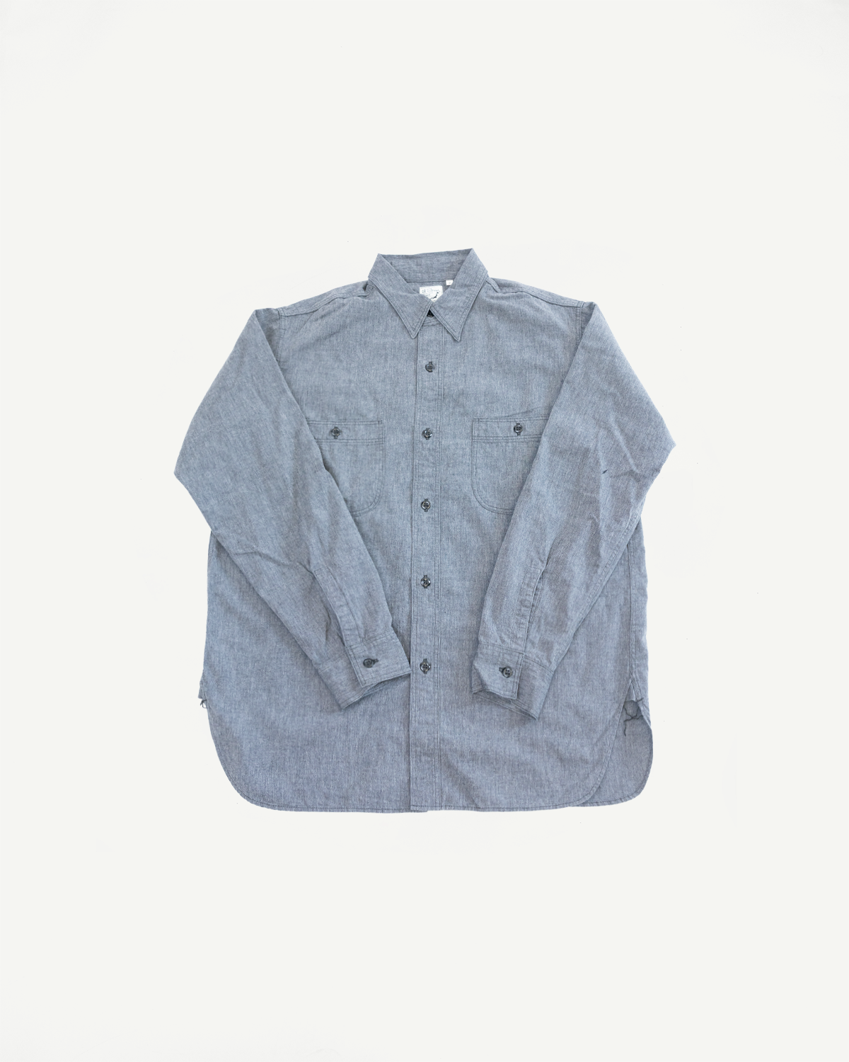 Front view flat lay of a grey long-sleeve button-down shirt with two chest pockets.