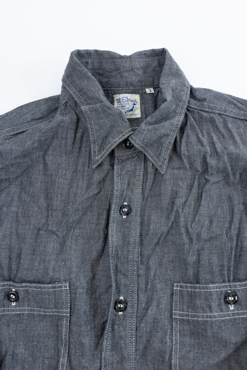 orSlow's 01-8270-61 Relaxed Fit Chambray Work Shirt in charcoal denim, featuring glossy black buttons, white top-stitching, and two chest pockets, showcasing a vintage-inspired, slightly wrinkled workwear aesthetic.