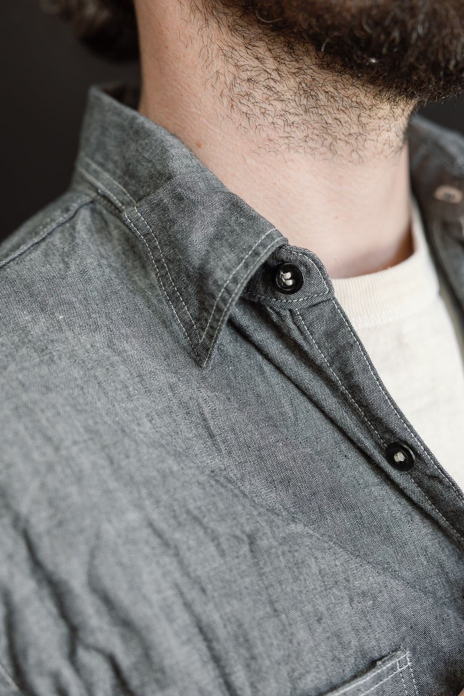 Relaxed Fit Chambray Work Shirt - Black, showcasing a grey button-down shirt with tonal buttons and a white crew-neck T-shirt underneath, highlighting classic 1940s workwear-inspired design and craftsmanship.