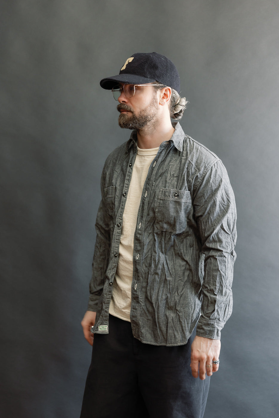 A man models the 01-8270-61 - Relaxed Fit Chambray Work Shirt - Black, showcasing its classic 1940s-inspired design with a relaxed fit, double chest pockets, and durable stitching.