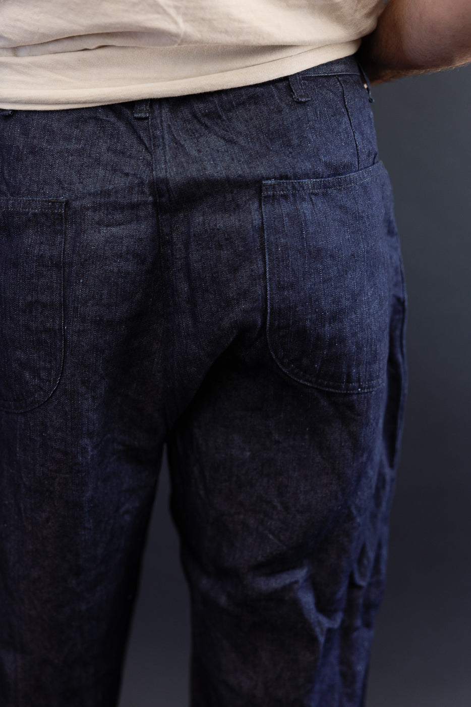Back view close-up of dark selvedge denim pants on male model, 5'9