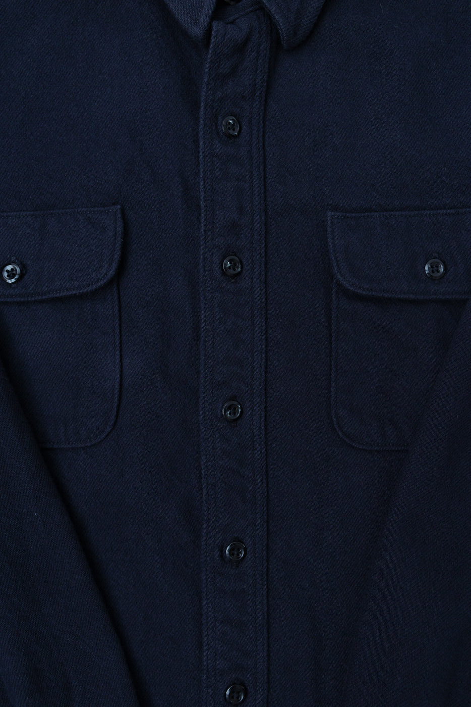 Close-up front view of navy flannel shirt, showing button placket and flap pockets