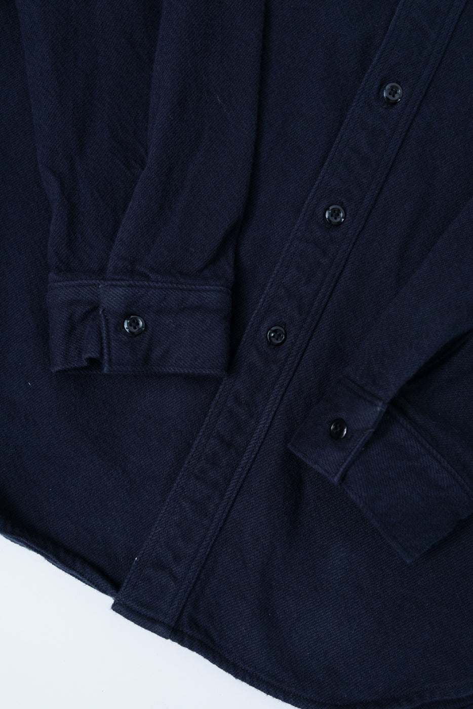Close-up of Orslow relaxed fit navy flannel shirt front, showing button cuffs and soft texture
