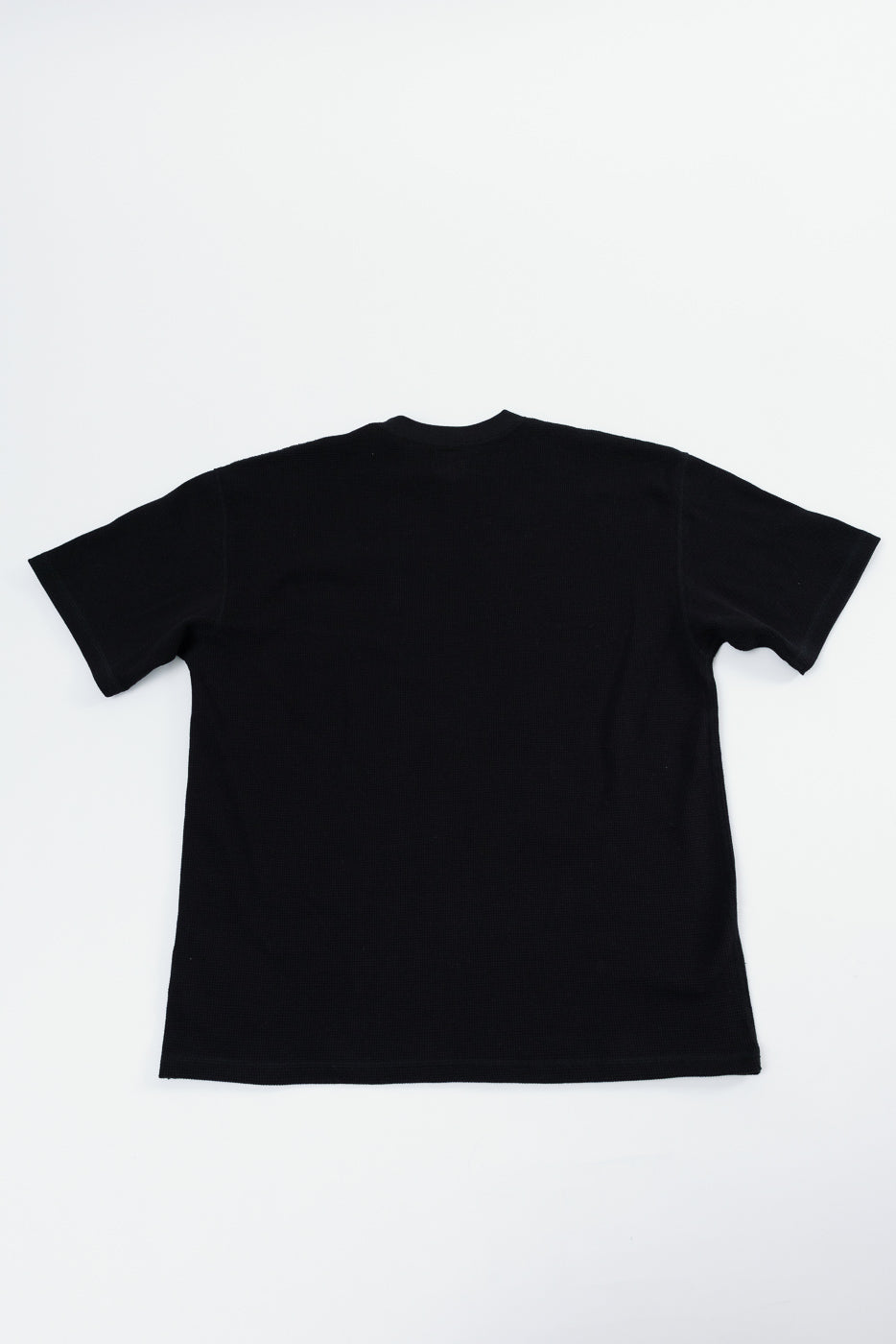 Back view of a plain black short sleeve t-shirt flat lay.