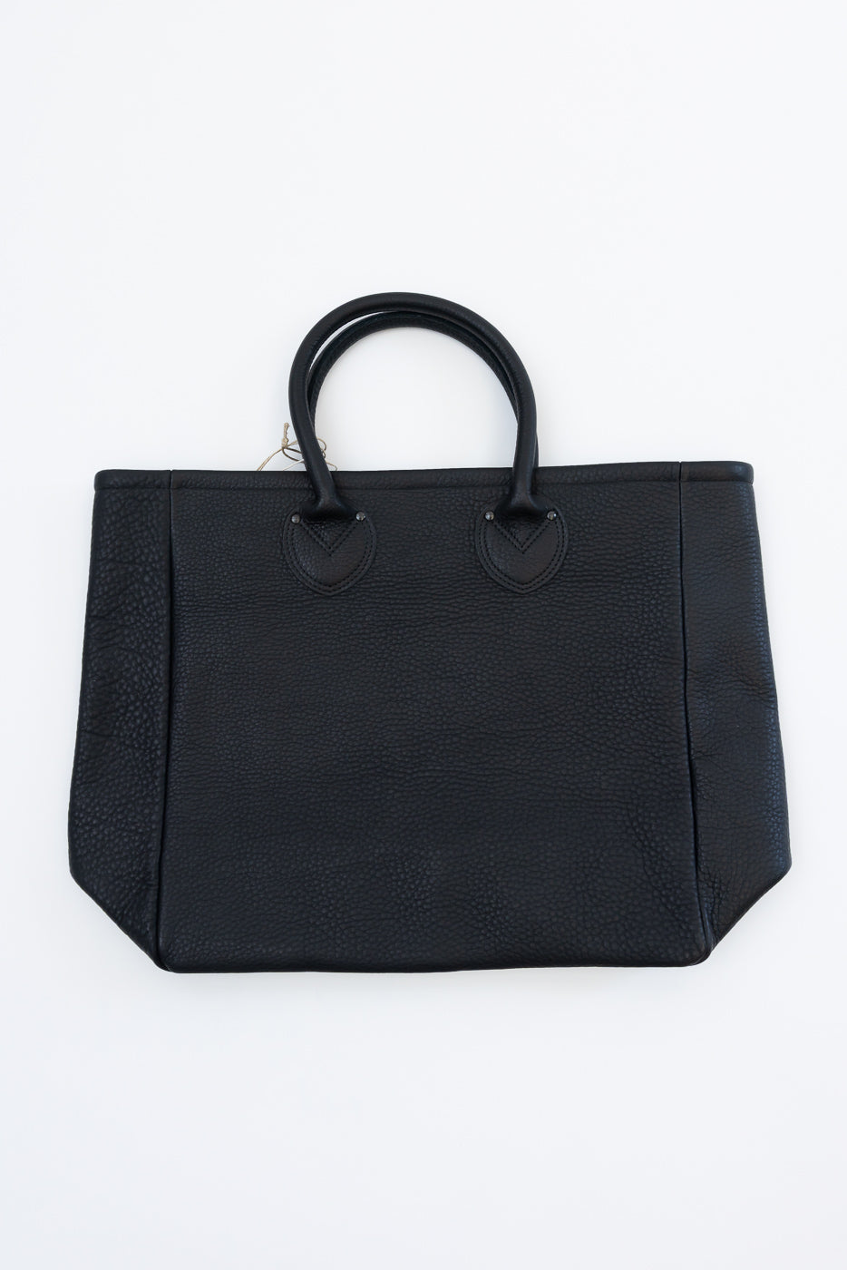 Black pebbled leather tote bag, front view, top handles, V-stitch detail, flat lay