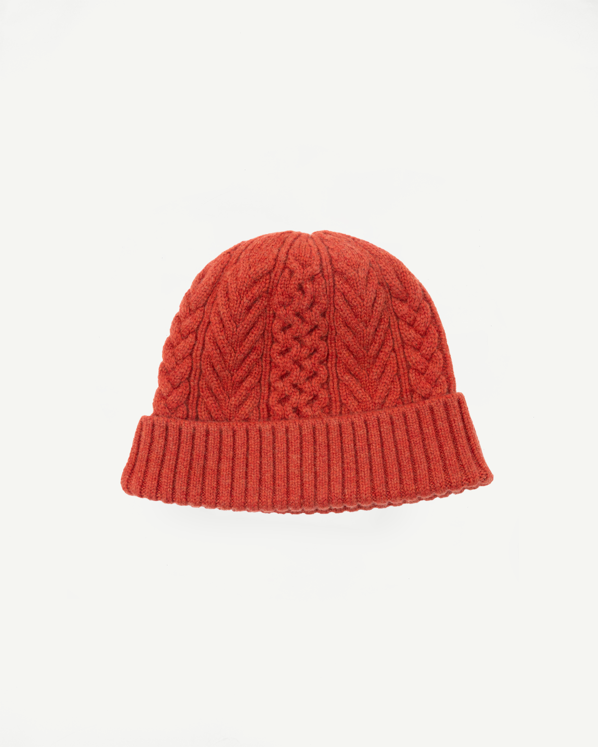 Front view flat lay of a red cable-knit beanie with a ribbed cuff.