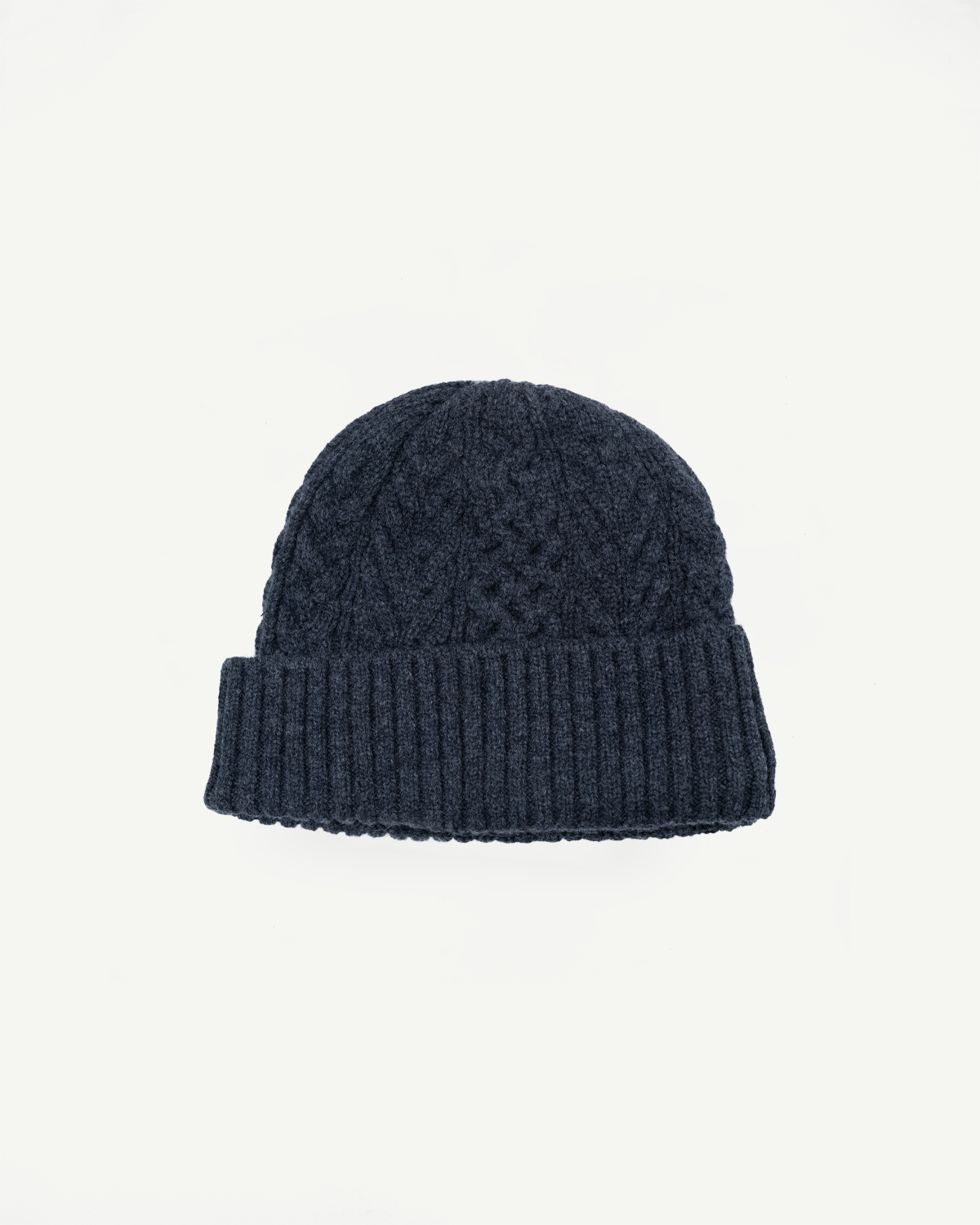Front view flat lay of a navy blue cable-knit beanie with a ribbed cuff.
