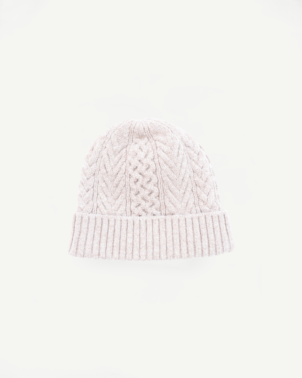 Front view close-up of a light pink cable knit beanie hat.