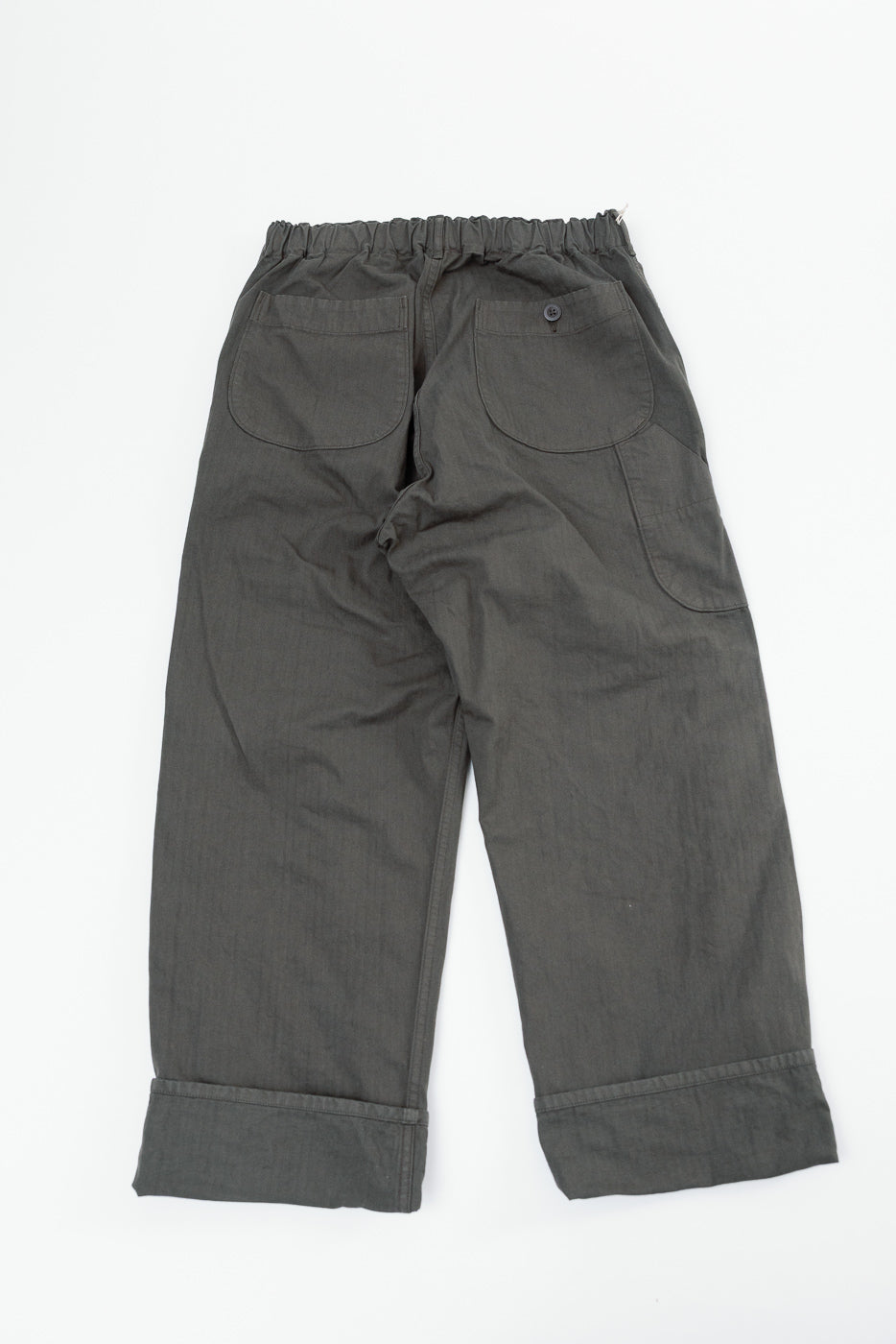 Back view flat lay of charcoal grey wide-leg trousers showing rear patch pockets and waistband.