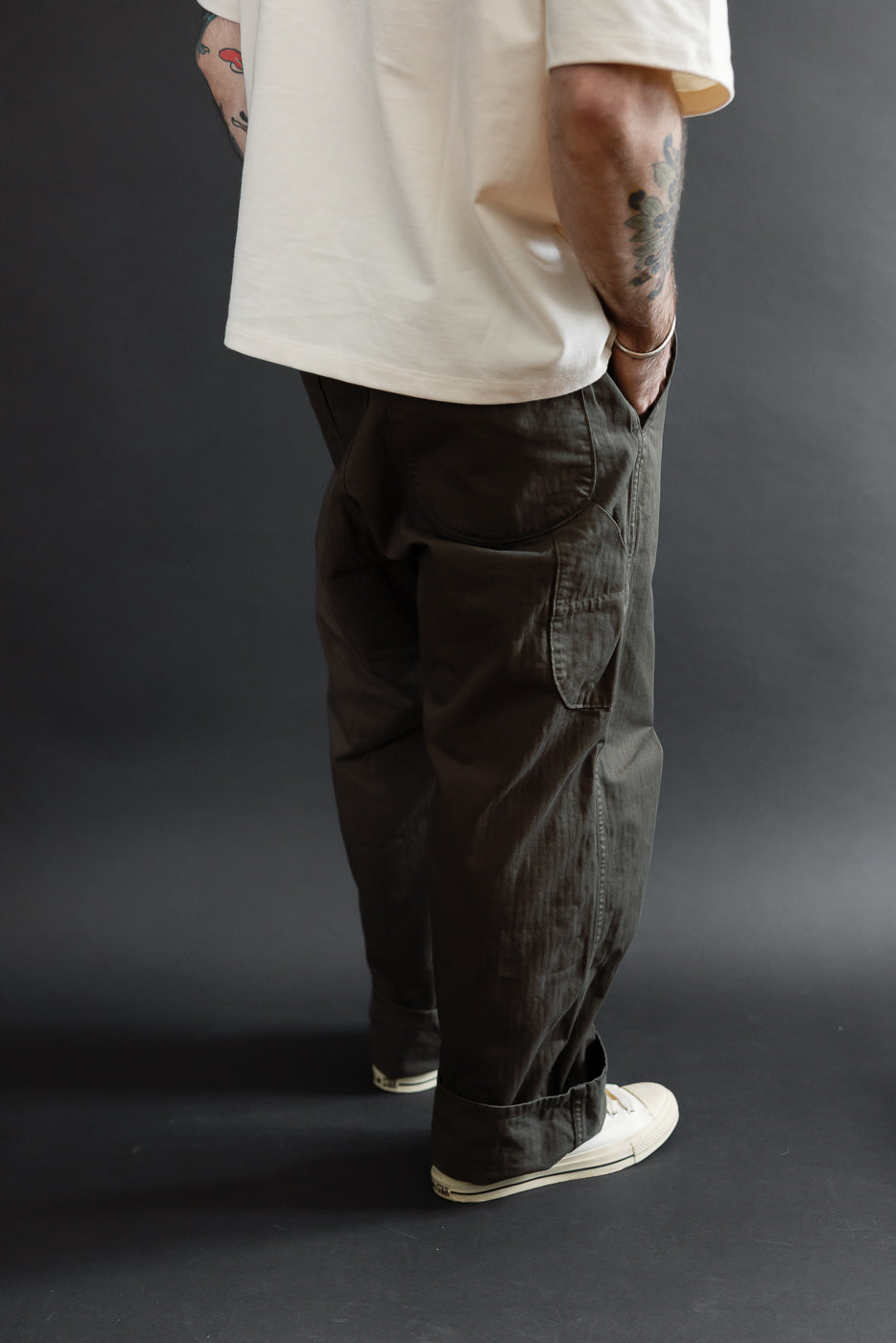 Rear view of olive cargo pants on a male model (5'9