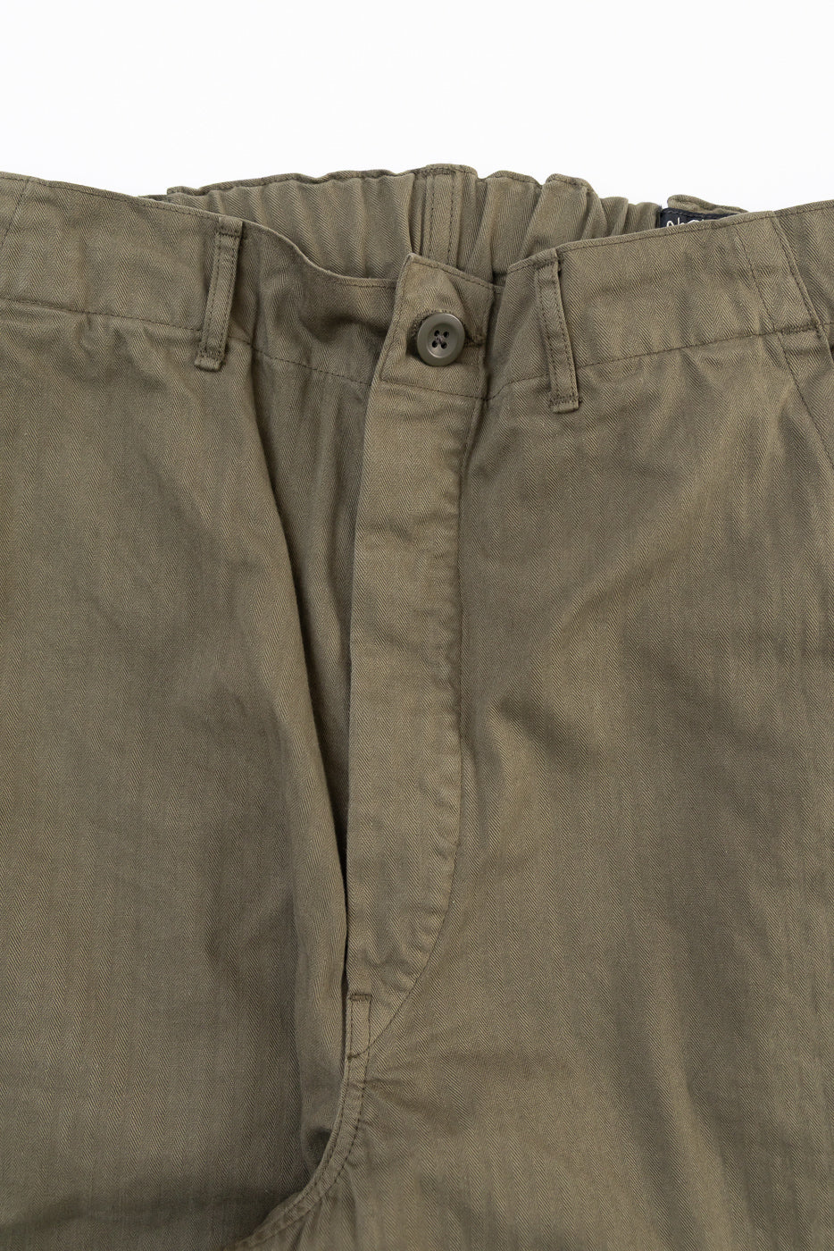 Close-up front view of olive green cotton trousers showing the waistband, button, and fly.