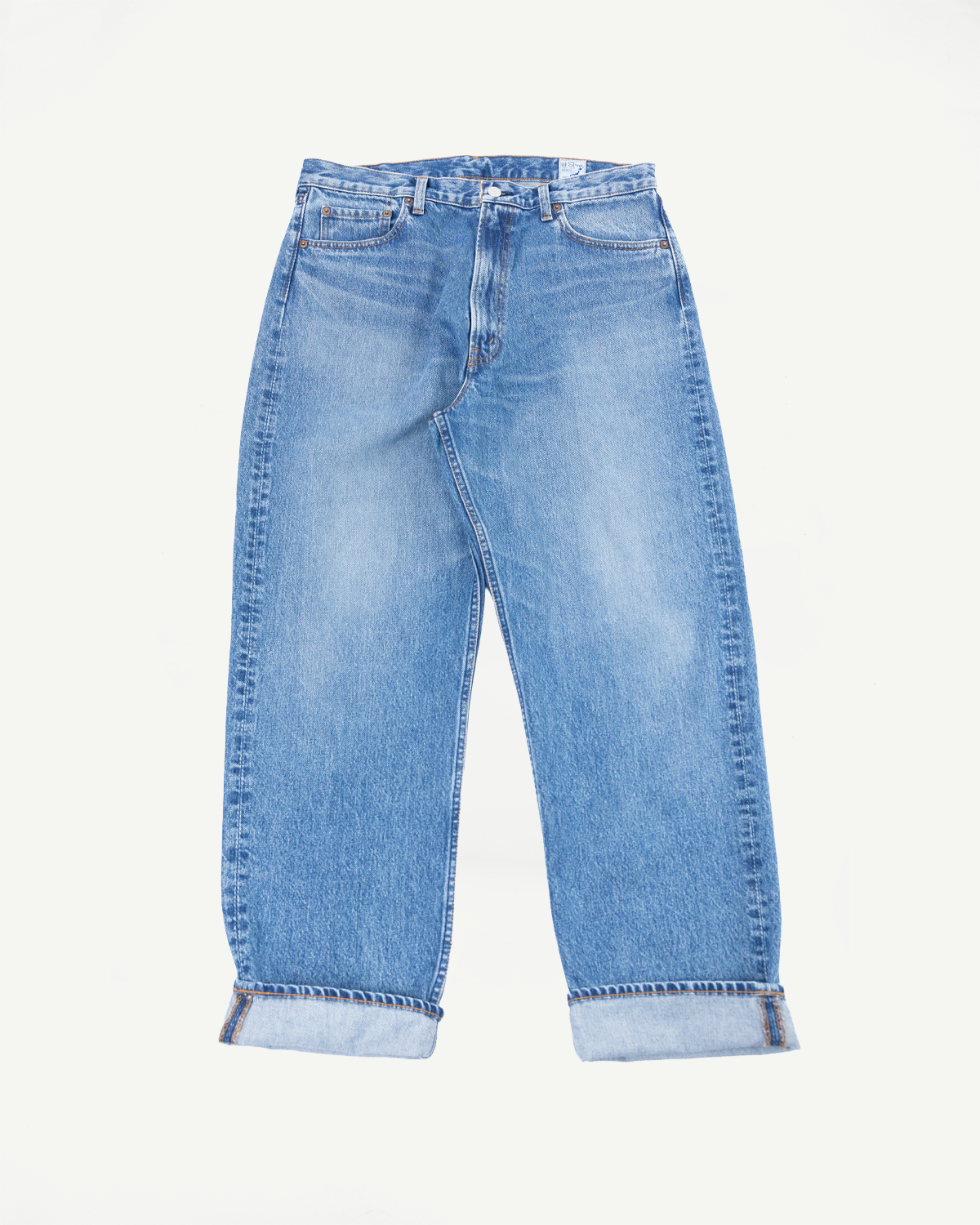 Front view flat lay of light wash blue denim jeans with cuffed hems.