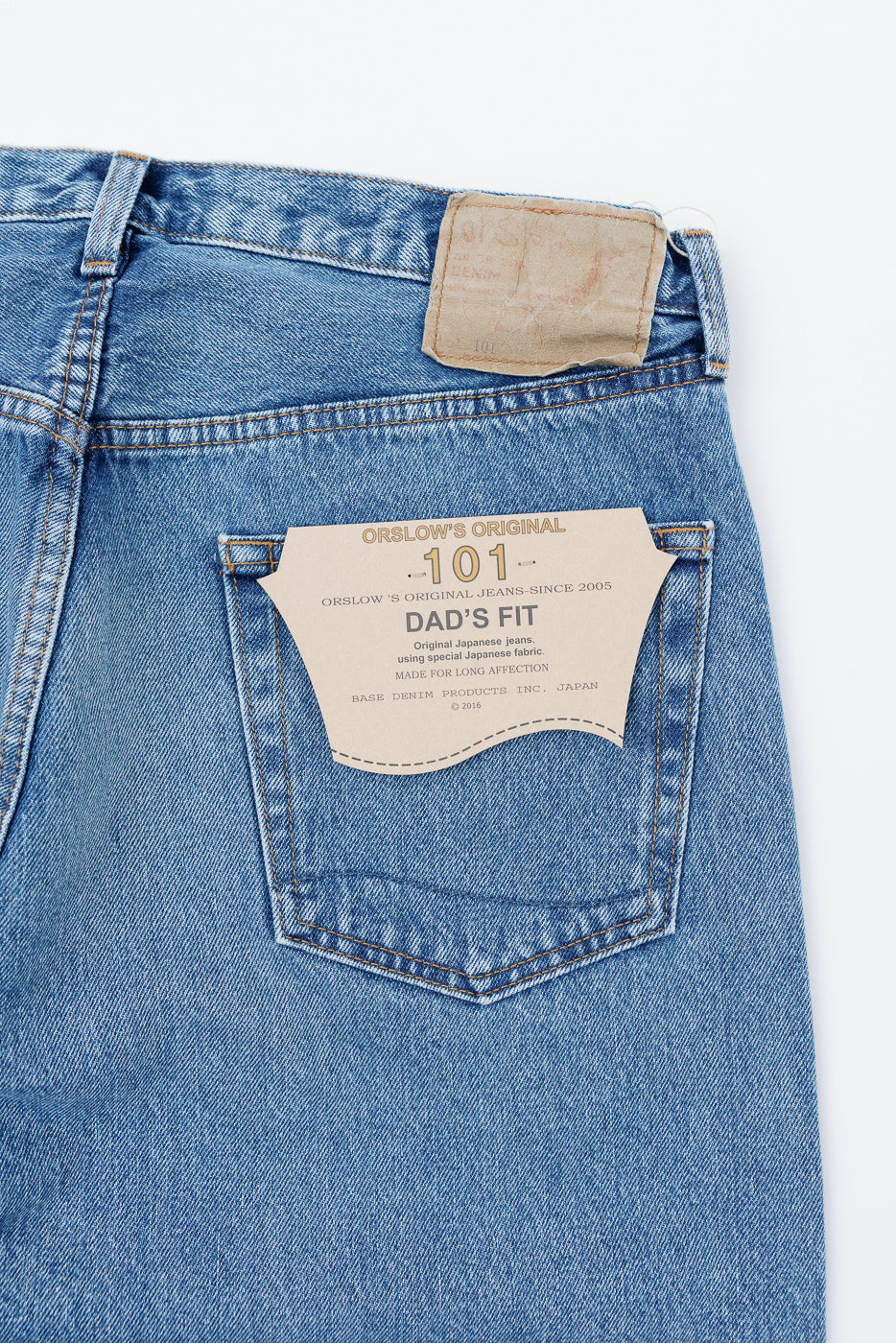 Flat lay, back view close-up of Orslow 101 Dad's Fit denim jeans showing leather patch and pocket.