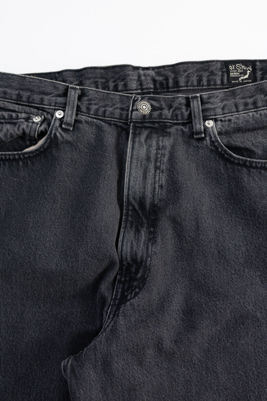 Close-up of orSlow black denim jeans front waist, button, pockets, and belt loops detail