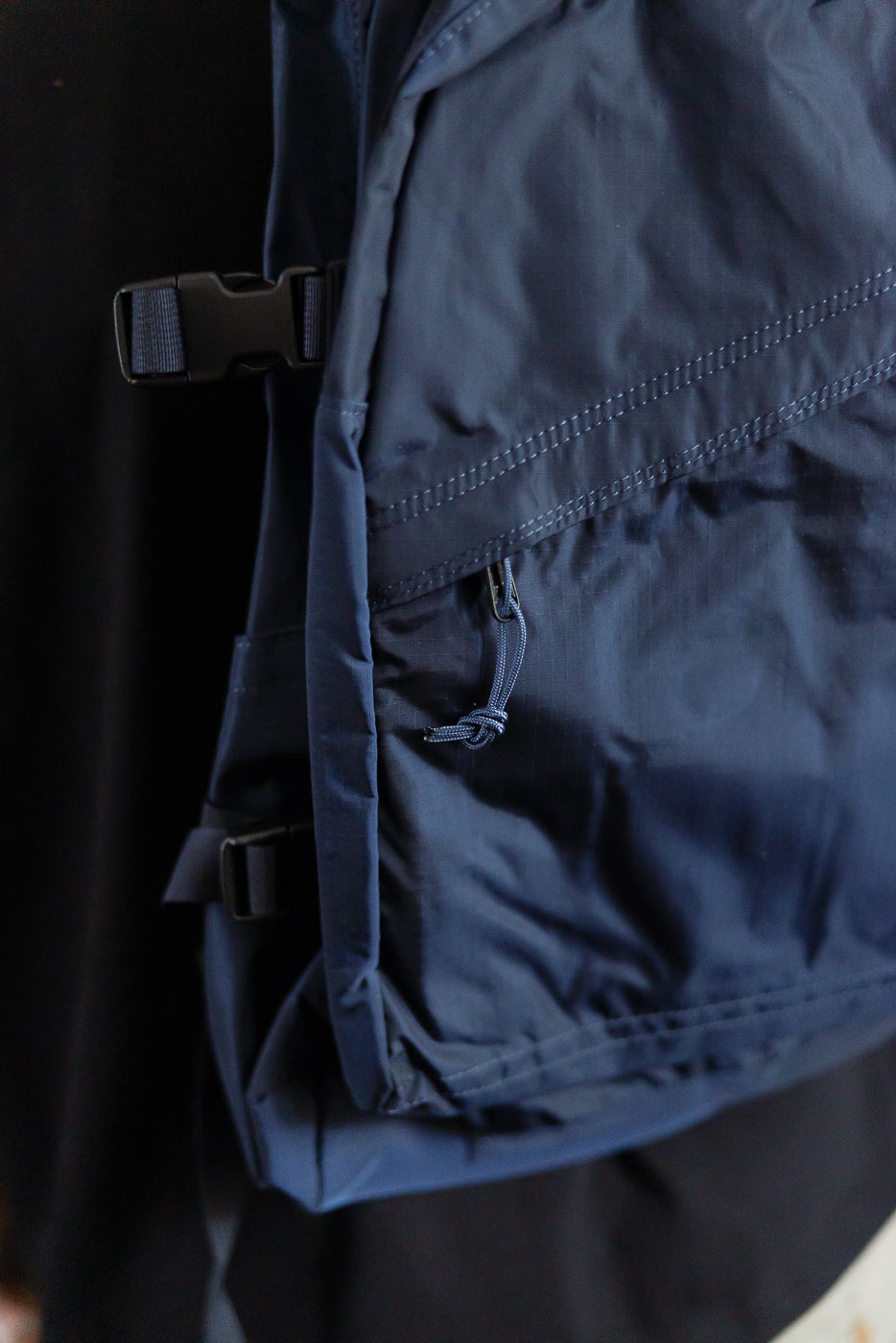 Close-up of navy nylon ripstop backpack side pocket and buckle from Dant contemporary casual accessories.