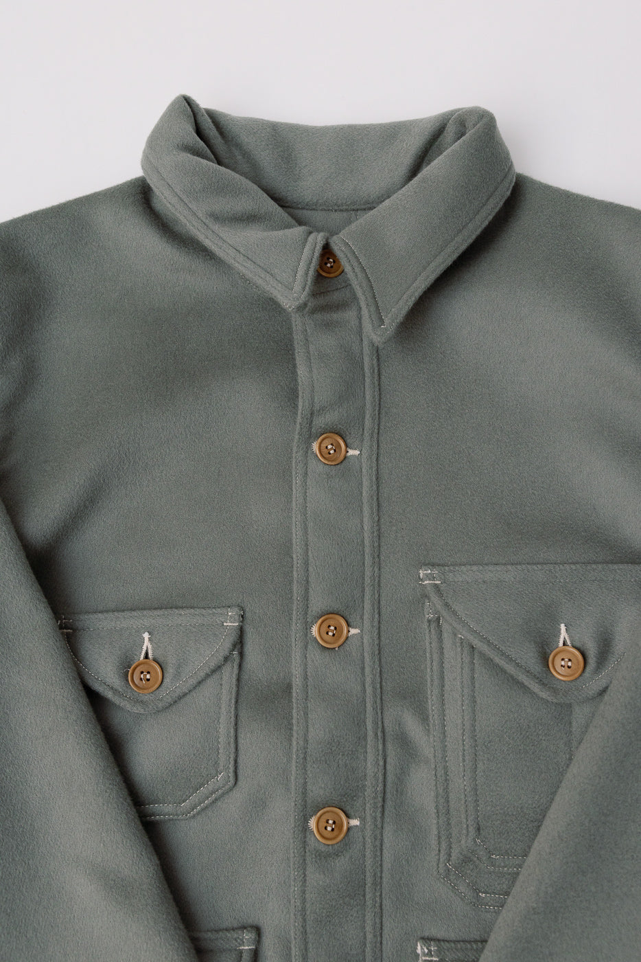 Close-up front detail of Post O'Alls pale green melton jacket, shows buttons, collar, pockets