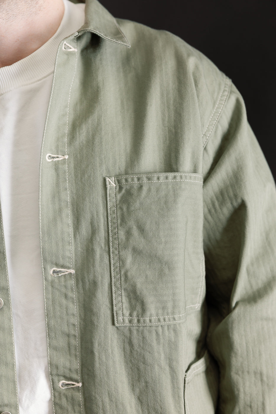 Close-up front of sage green utility jacket on male model, 5'9