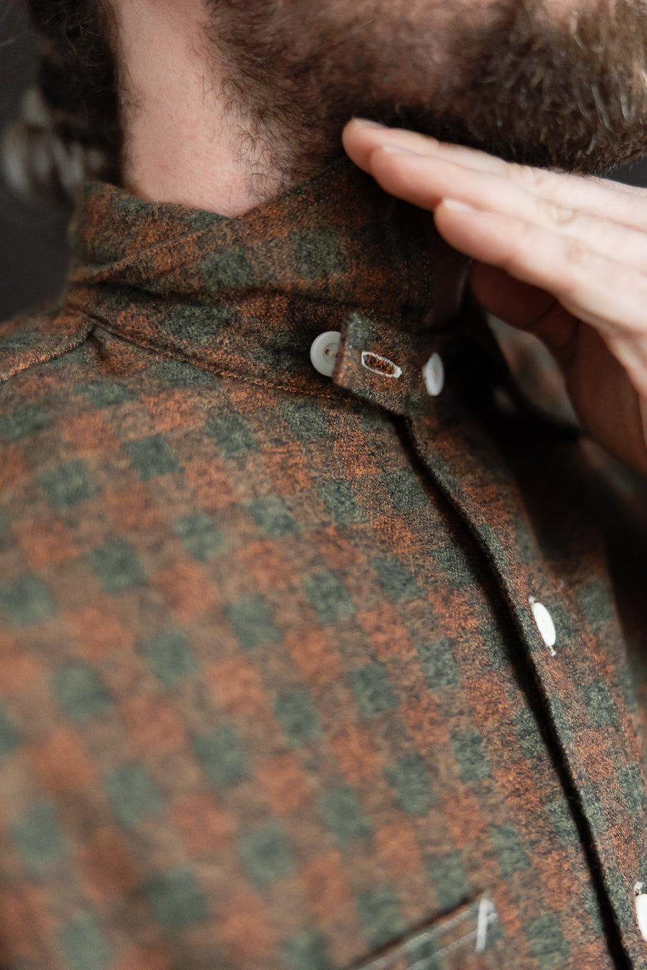 Close-up of front collar and buttons on men's orange plaid cotton flannel shirt, model 5'9 165lbs athletic build