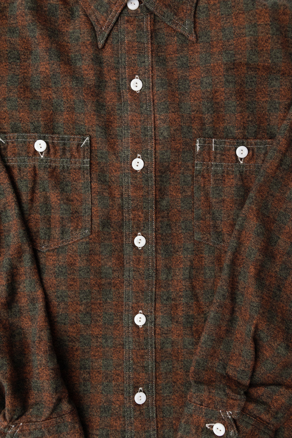 Close-up front view of orange block plaid cotton flannel shirt, showing buttons and pockets.