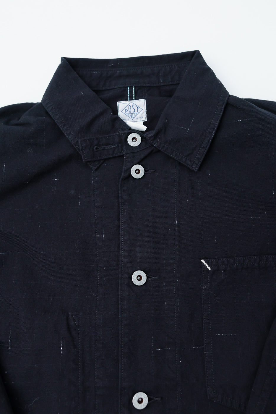 Close-up front detail of Post O'Alls 46 Coverall in black nep twill showing collar, buttons, and chest pocket.