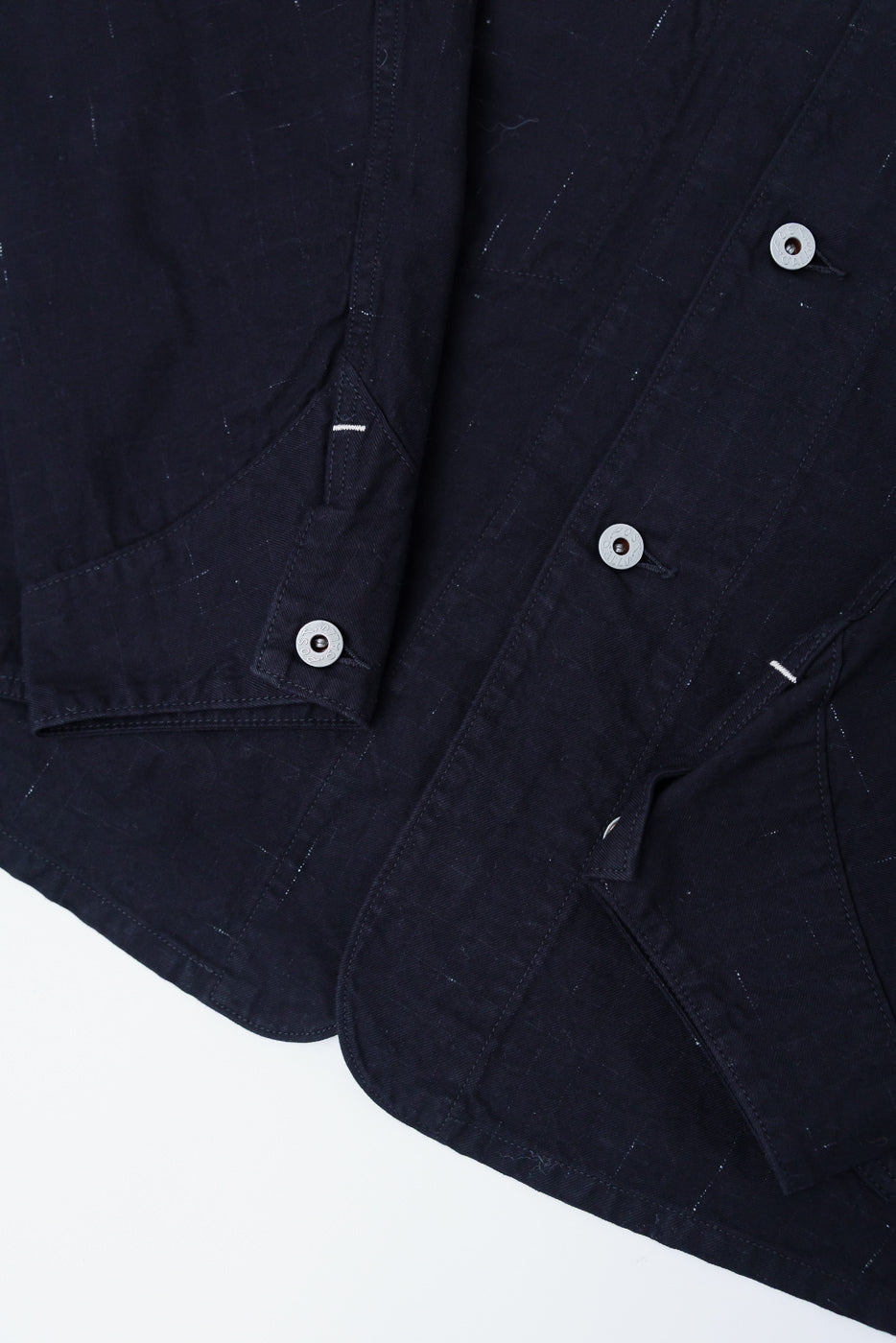 Close-up of front lower section, black nep twill coverall, pocket and button details