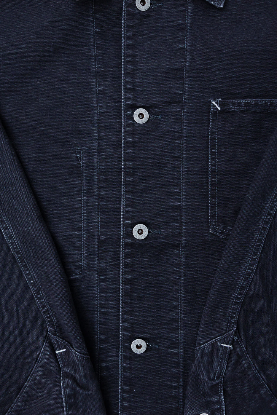 Close-up of Post O'Alls 3133 PCB Post 46 Coverall front, showing black pigment-dyed canvas, silver buttons, and front chest pocket at Dant.