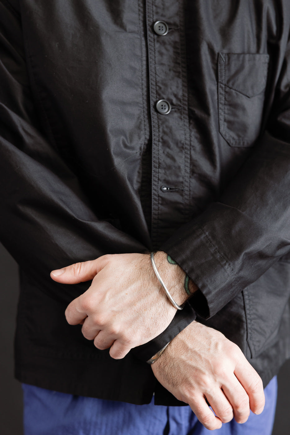 Close-up front of black button-up work jacket on male model, 5'9